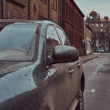 Outdoor parked car exposed to sunlight, rain, and dust causing long-term vehicle damage