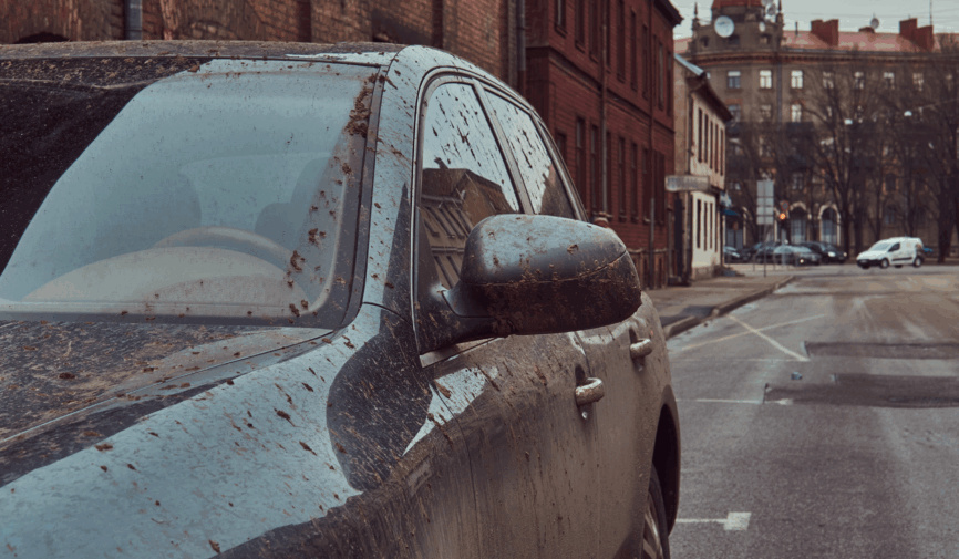 Outdoor parked car exposed to sunlight, rain, and dust causing long-term vehicle damage