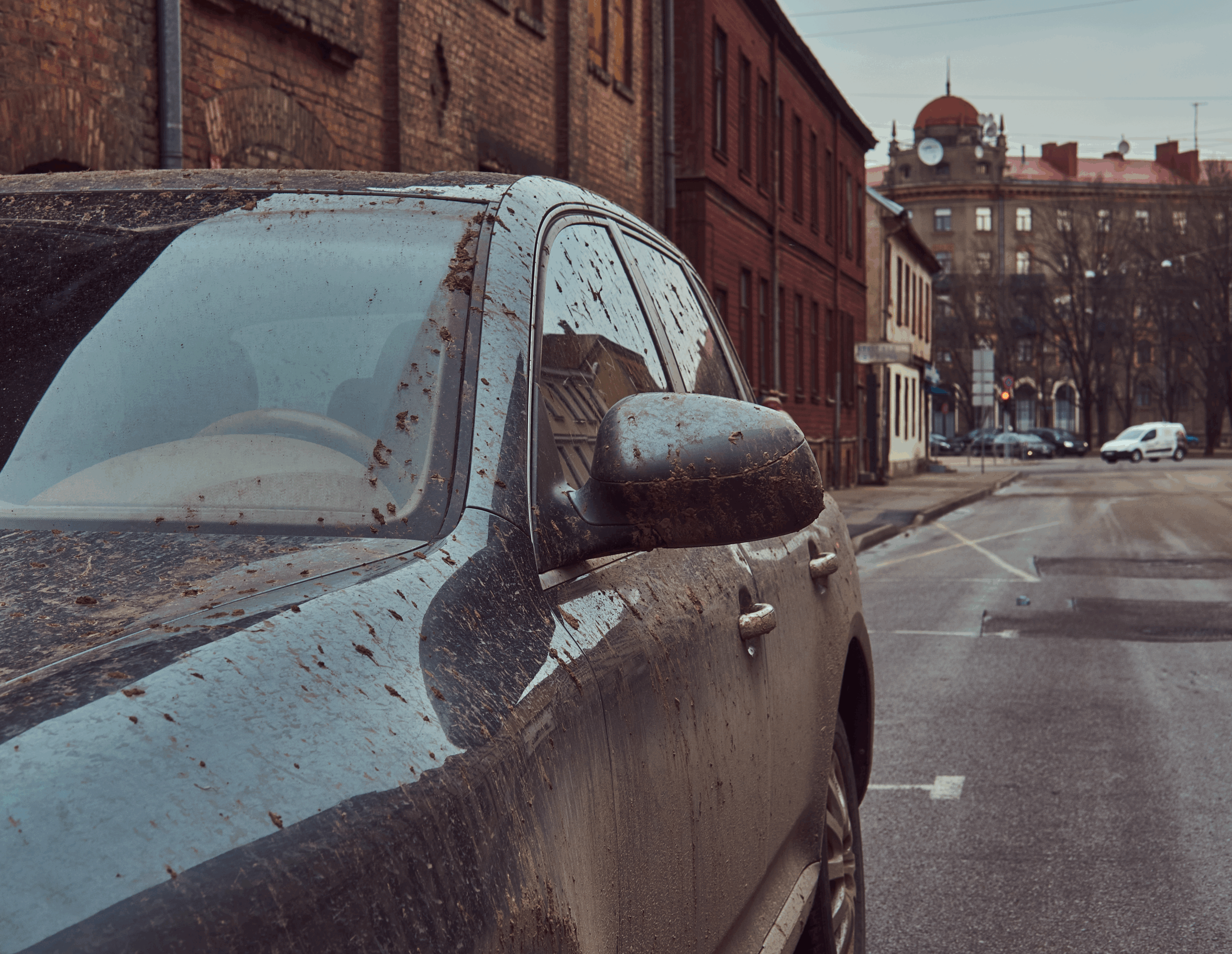 Outdoor parked car exposed to sunlight, rain, and dust causing long-term vehicle damage